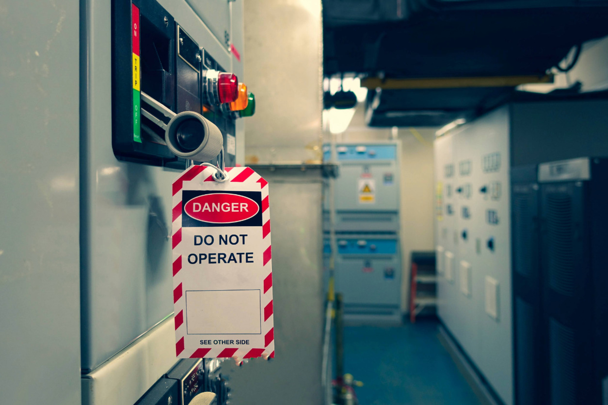 Etiqueta de consignación LOTO con aviso de peligro en un cuadro eléctrico.